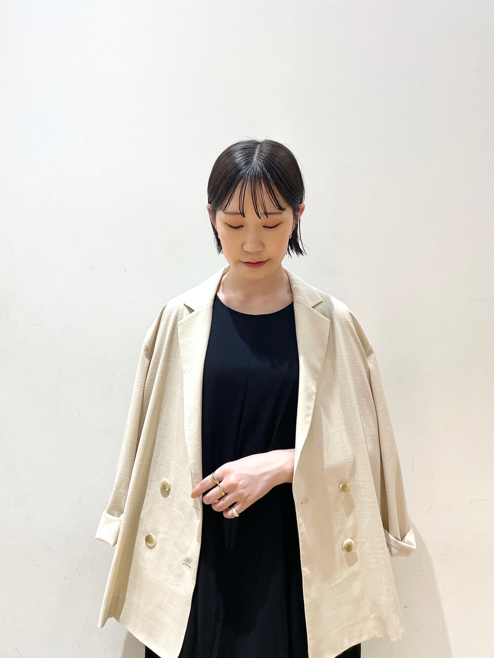 ブラック系のハンドバッグ、ベージュ系のテーラードジャケット、ブラック系のワンピースを着用したレディースの夏コーディネートの8枚目の写真