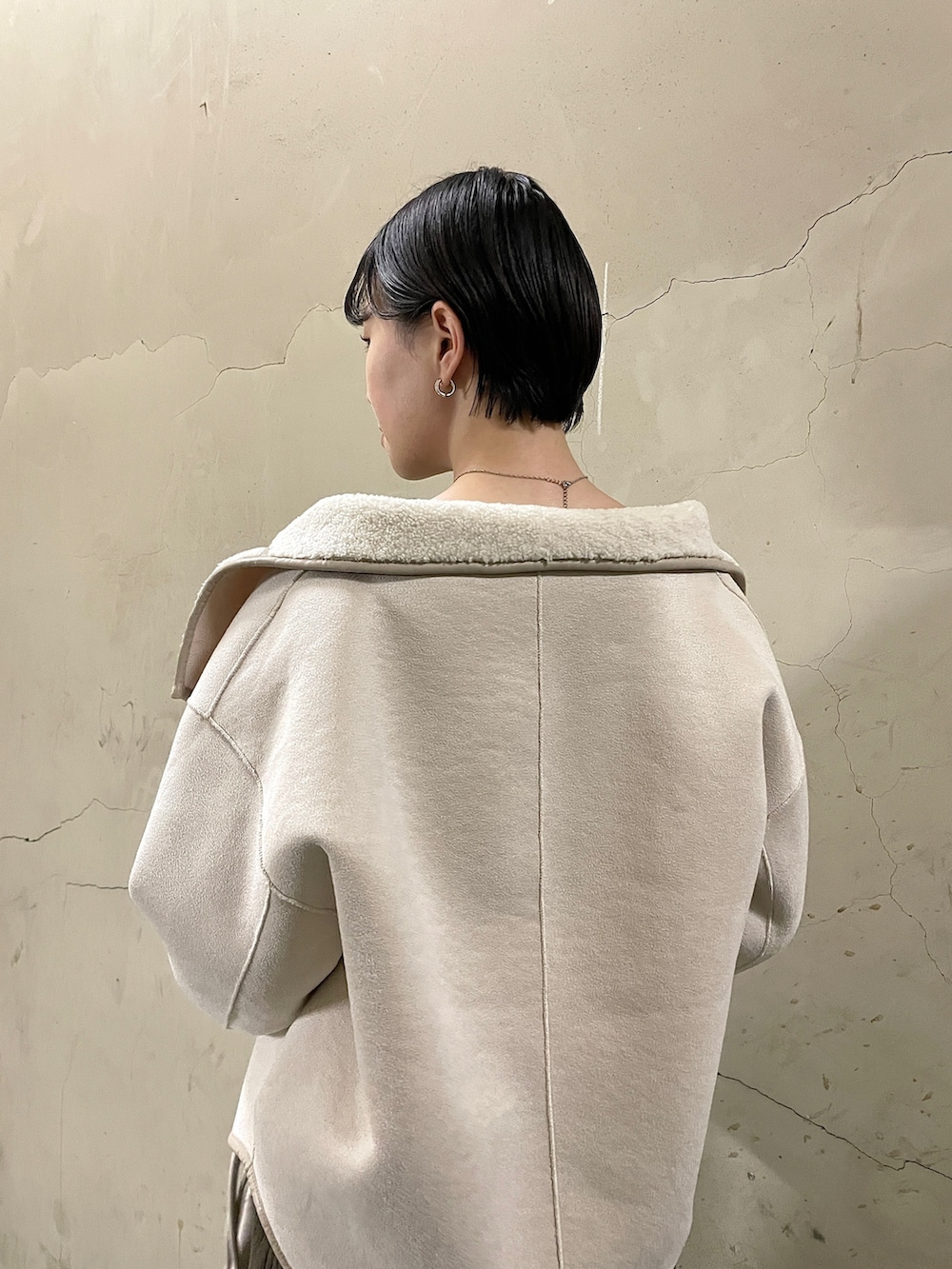 ホワイト系のブルゾン、ブラック系のブーツ、ブラウン系のワンピースを着用したレディースの秋コーディネートの9枚目の写真