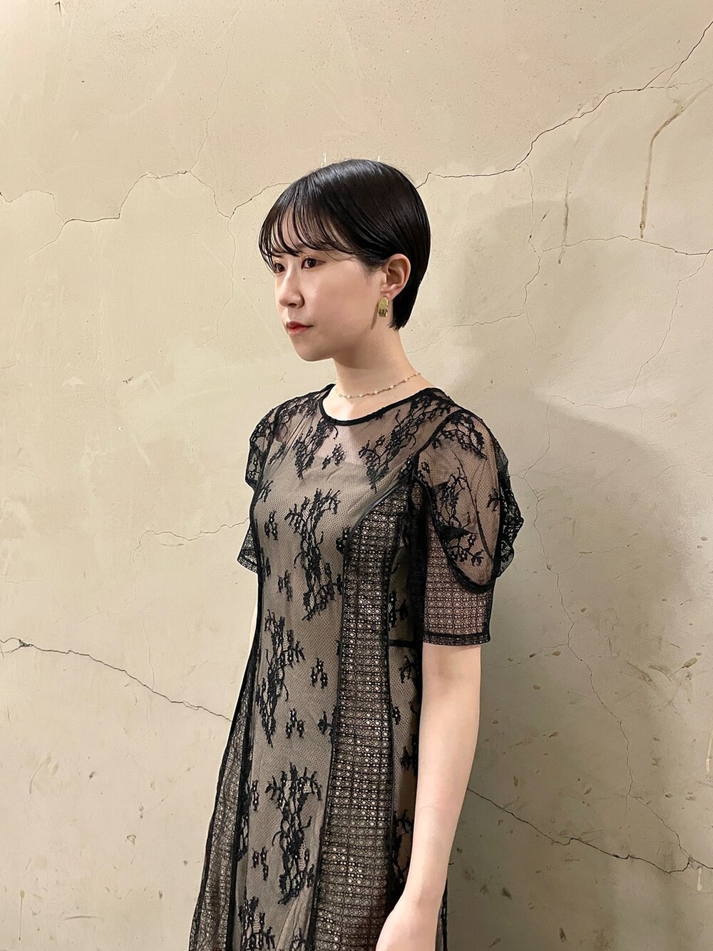 ブラック系のドレス、ゴールド系のハンドバッグ、ゴールド系のパンプスを着用したレディースの秋コーディネートの5枚目の写真