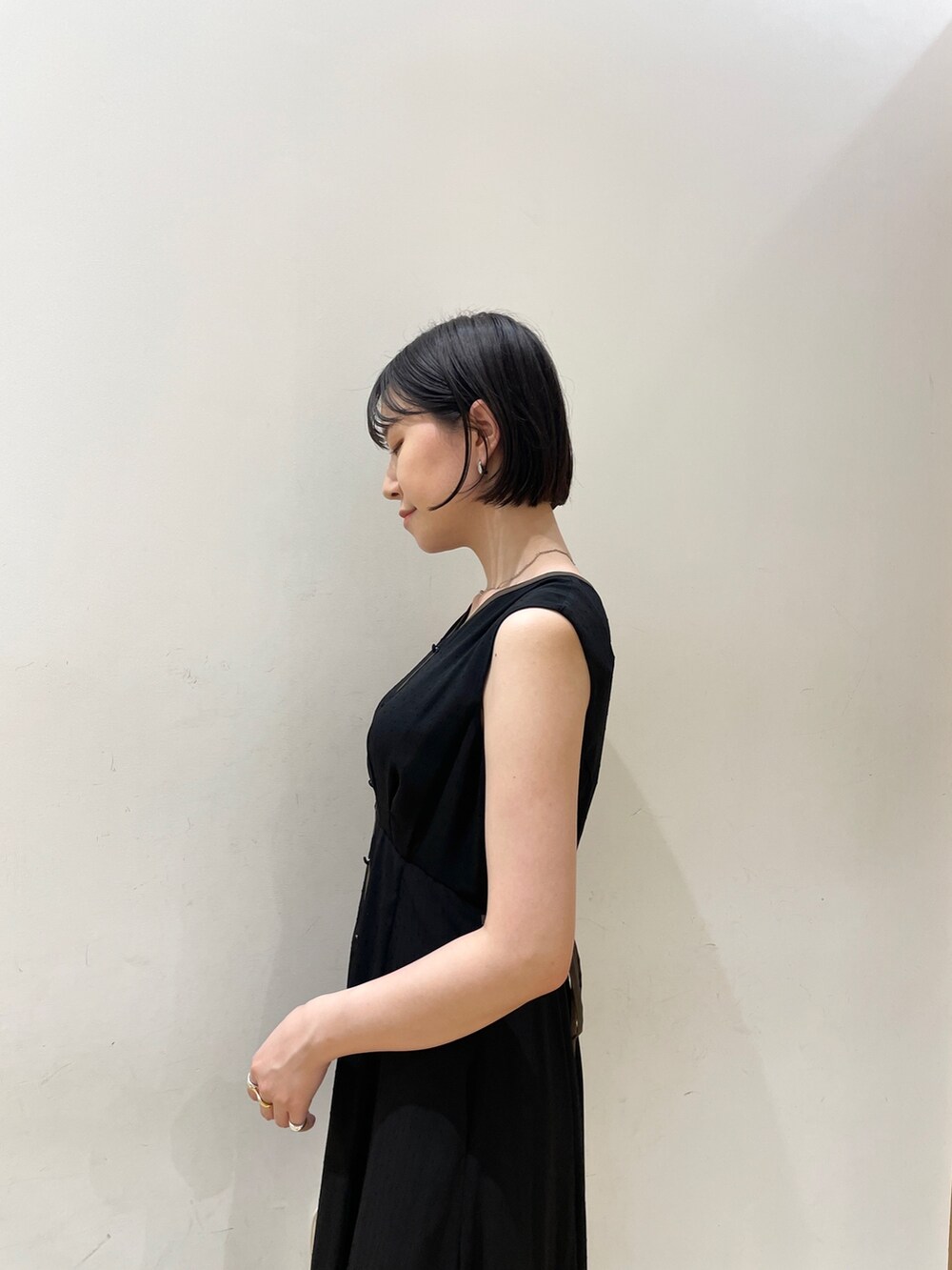 ホワイト系のショルダーバッグ、ベージュ系のサンダル、ブラック系のワンピースを着用したレディースの夏コーディネートの6枚目の写真