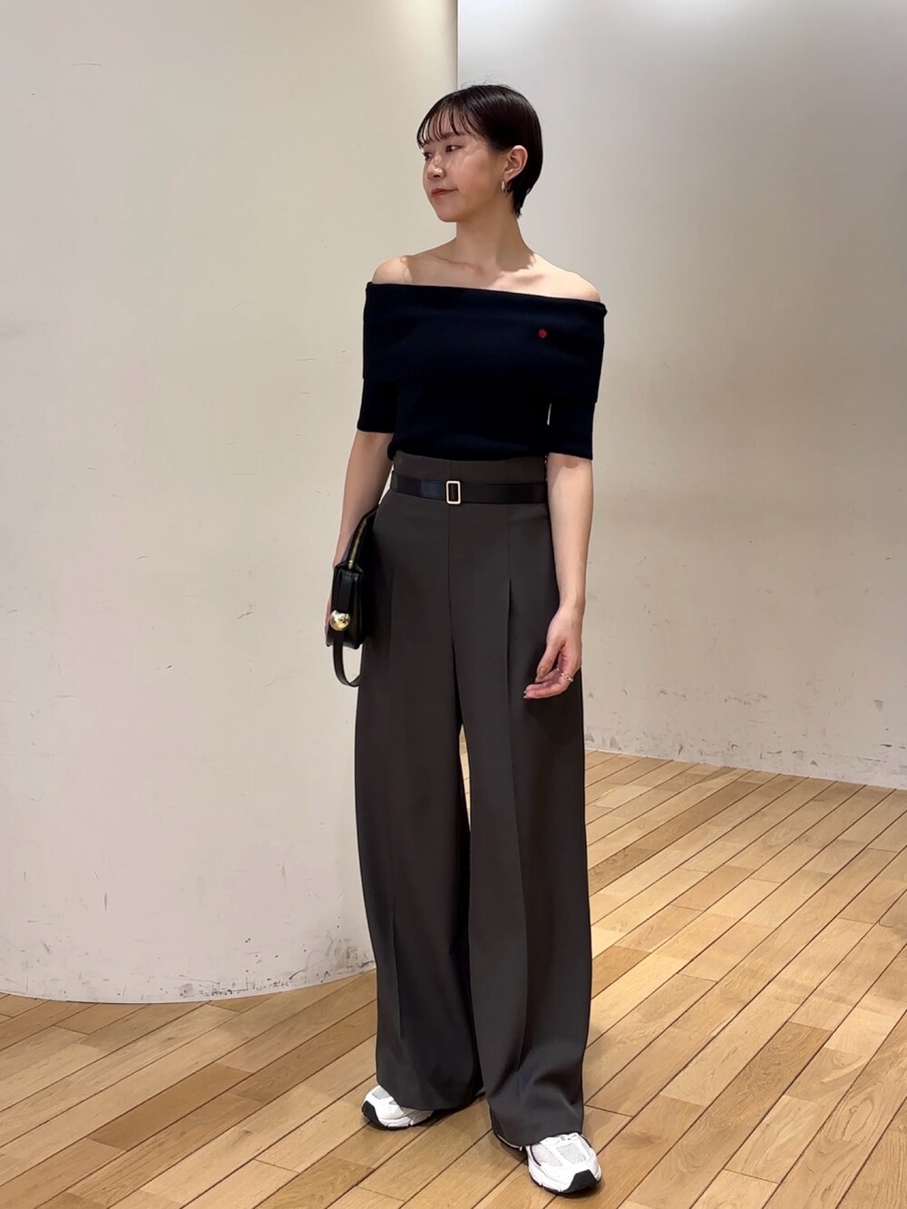 グレー系のその他パンツ、ブルー系のニット/セーター、ブラック系のショルダーバッグを着用したレディースの春コーディネートの2枚目の写真