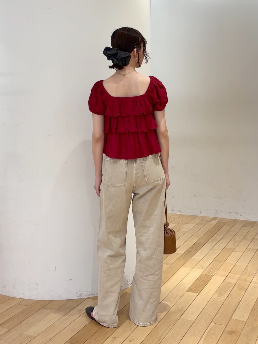 ベージュ系のデニムパンツ、レッド系のシャツ/ブラウス、イエロー系のハンドバッグを着用したレディースの夏コーディネートの4枚目の写真