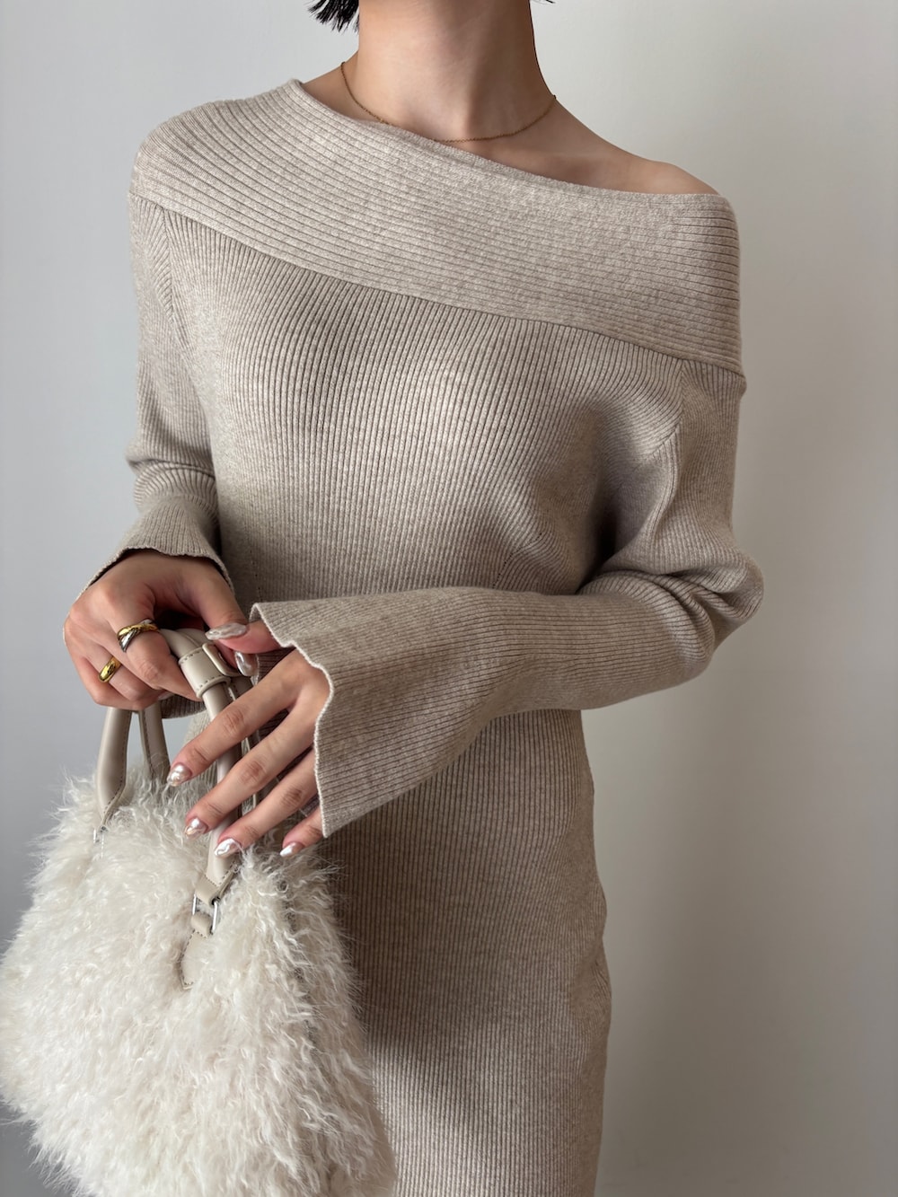 ベージュ系のワンピース、ホワイト系のボストンバッグ、ブラウン系のブーツを着用したレディースの秋コーディネートの6枚目の写真