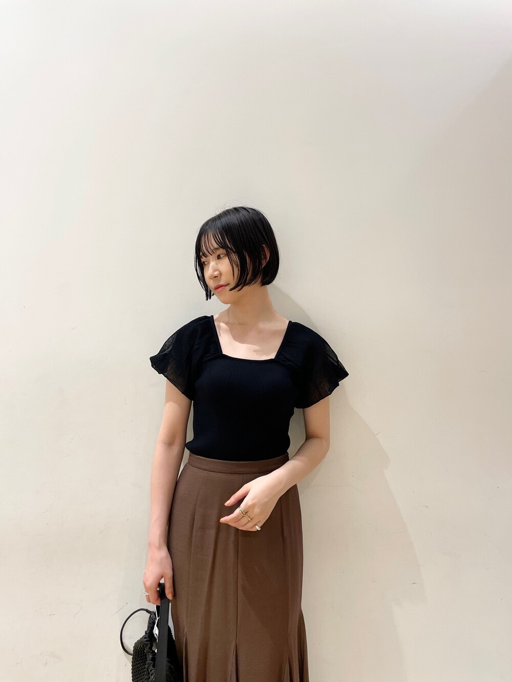 ブラウン系のスカート、ブラウン系のサンダル、ブラック系のハンドバッグを着用したレディースの夏コーディネートの6枚目の写真