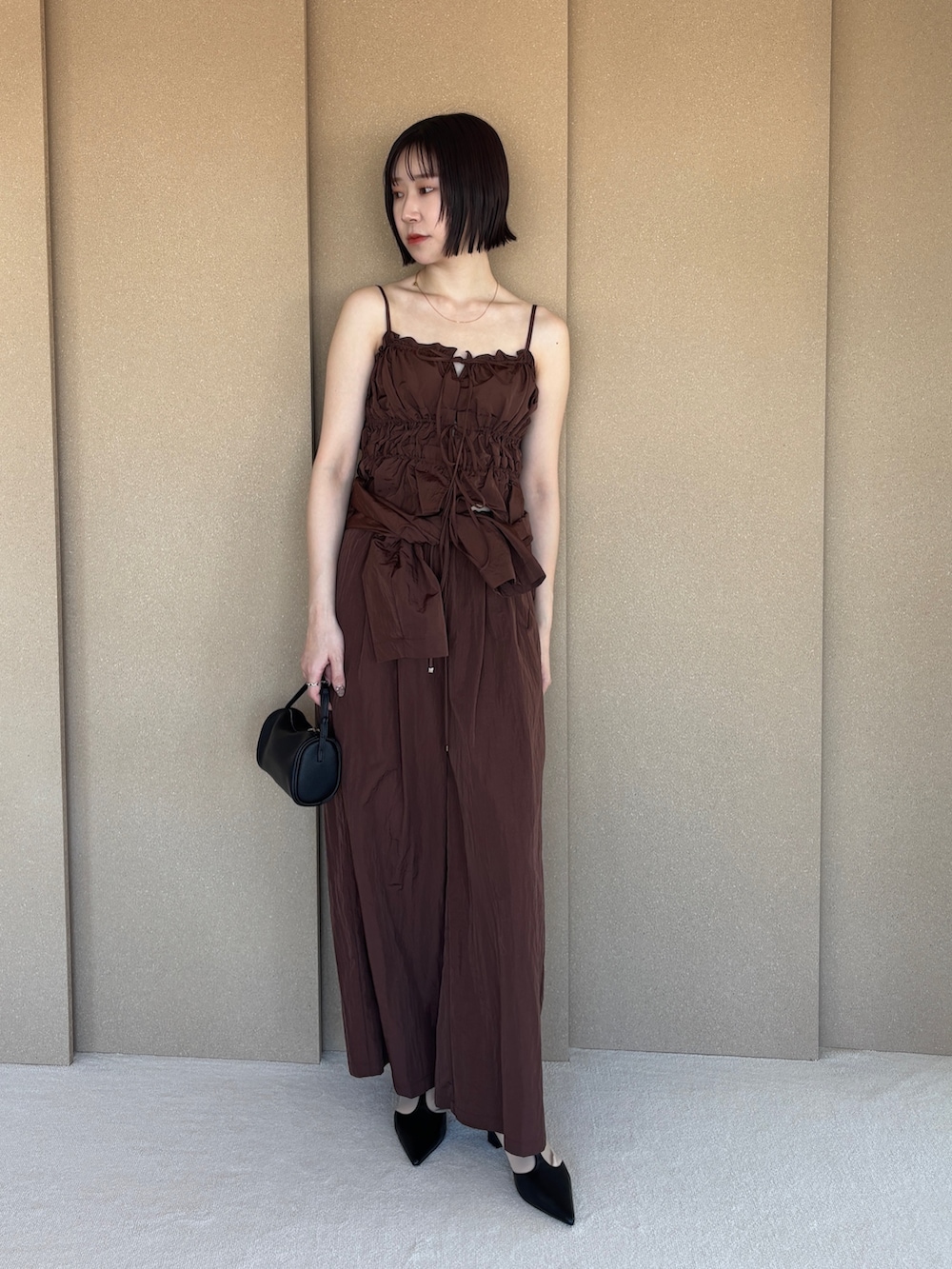 ブラウン系のその他パンツ、ブラック系のパンプス、ブラウン系のキャミソールを着用したレディースの春コーディネートの2枚目の写真
