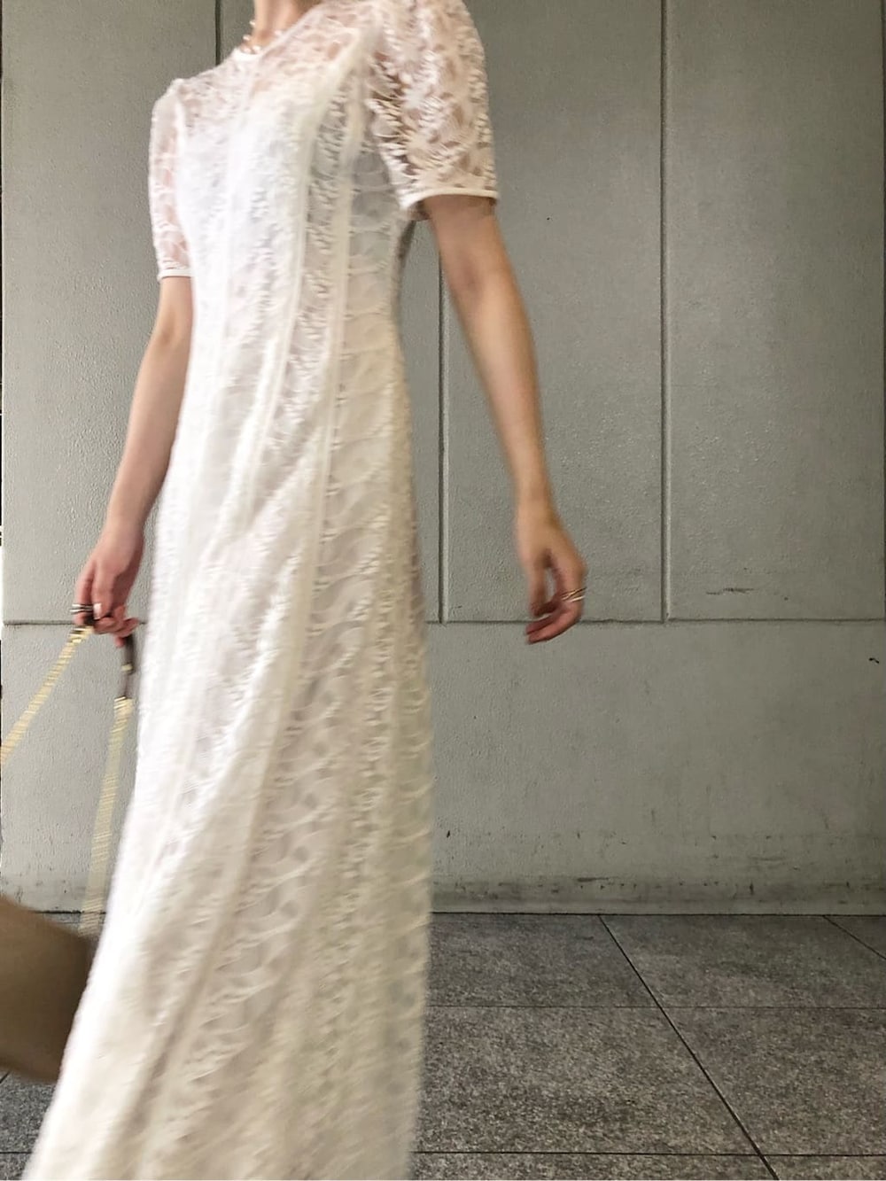 ホワイト系のドレス、ゴールド系のパンプス、ゴールド系のクラッチバッグを着用したレディースの夏コーディネートの4枚目の写真