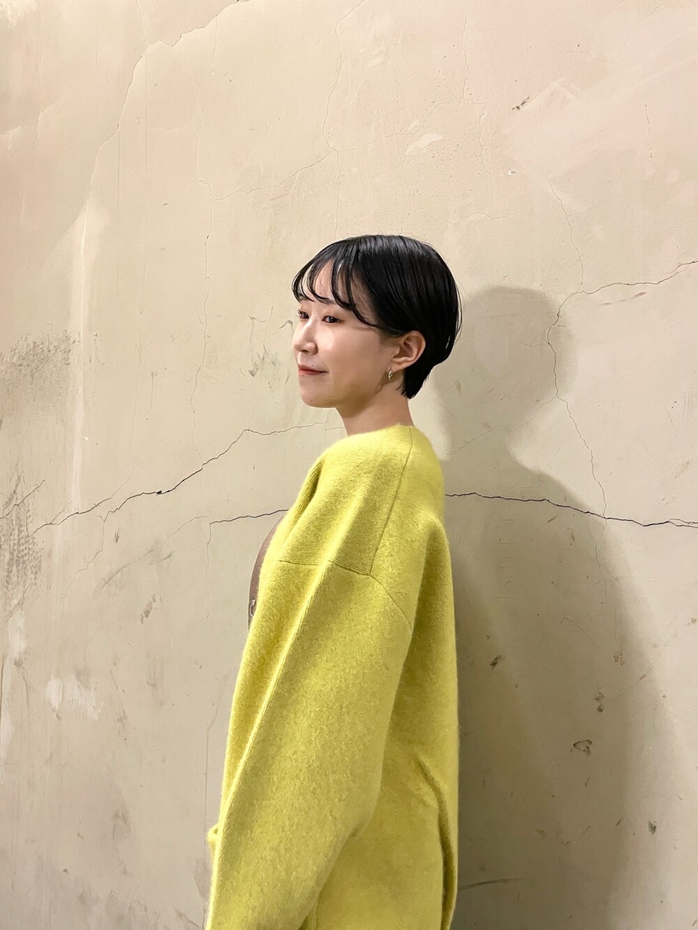 ブラック系のニット/セーター、イエロー系のカーディガン/ボレロ、ブルー系のデニムパンツを着用したレディースの秋コーディネートの5枚目の写真