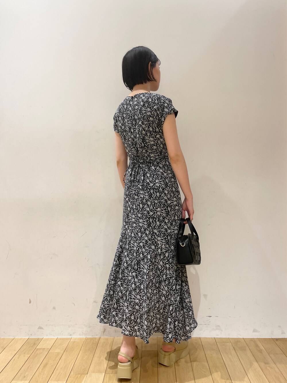 ブラック系のワンピース、ブラック系のショルダーバッグ、ベージュ系のサンダルを着用したレディースの夏コーディネートの4枚目の写真