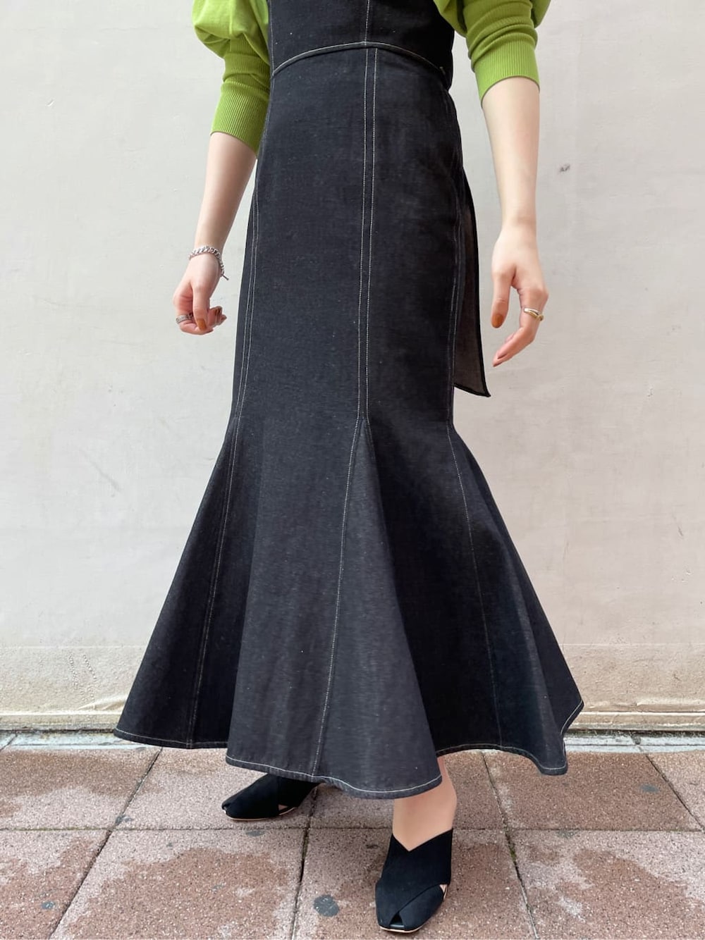 ブラック系のワンピース、グリーン系のニット/セーター、ブラック系のサンダルを着用したレディースの春コーディネートの5枚目の写真