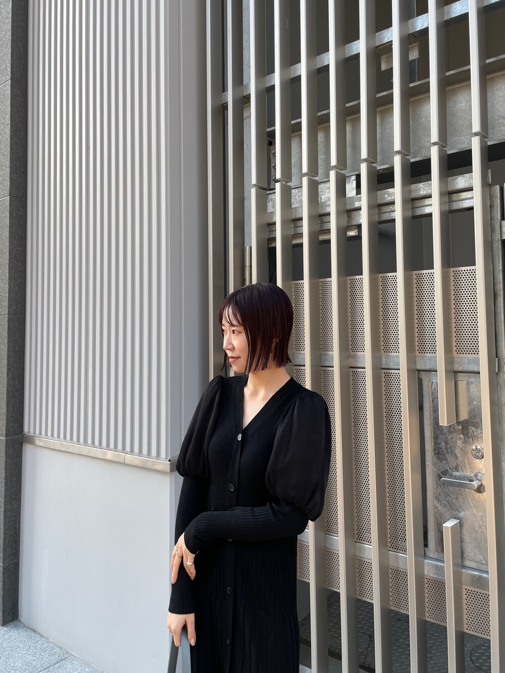 ブラック系のワンピース、ブルー系のショルダーバッグ、ホワイト系のブーツを着用したレディースの冬コーディネートの4枚目の写真