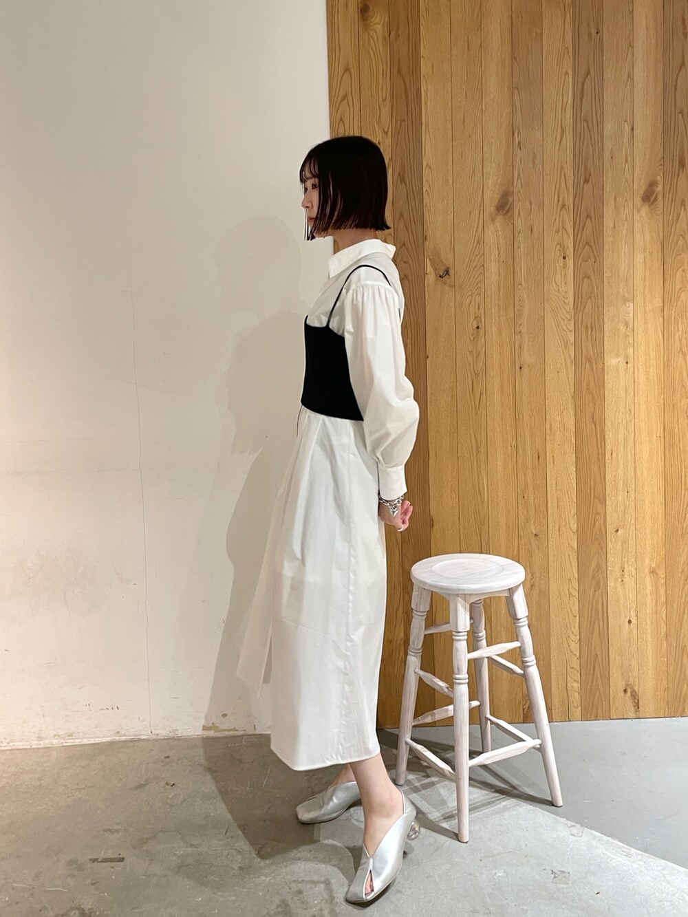 シルバー系のパンプス、ホワイト系のシャツワンピース、ブラック系のデニムジャケットを着用したレディースの冬コーディネートの4枚目の写真