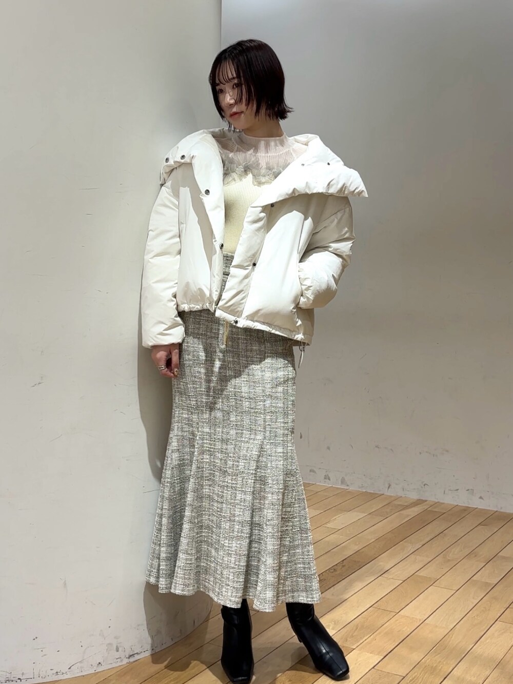 ブラック系のブーツ、ホワイト系のニット/セーター、ホワイト系のスカートを着用したレディースの冬コーディネートの7枚目の写真