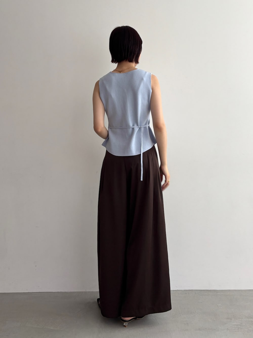 ブラウン系のその他パンツ、グレー系のニット/セーターを着用したレディースの夏コーディネートの3枚目の写真