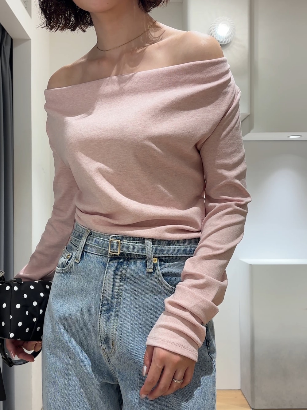 ピンク系のニット/セーター、ブルー系のデニムパンツ、ブラック系のブーツを着用したレディースの秋コーディネートの4枚目の写真