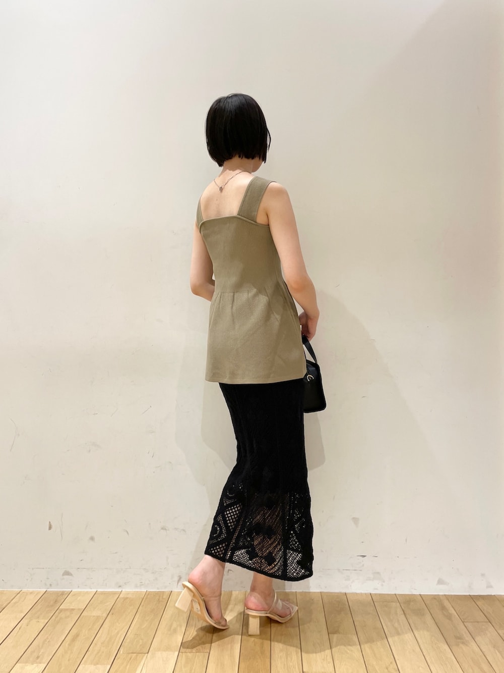 ブラック系のスカート、ブラック系のショルダーバッグ、その他のサンダルを着用したレディースの夏コーディネートの4枚目の写真