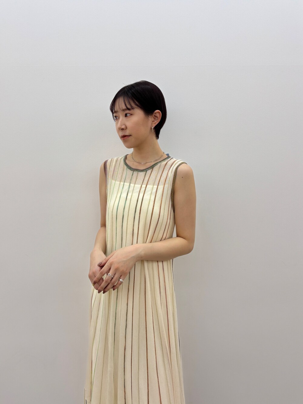 ホワイト系のワンピース、ホワイト系のサンダル、シルバー系のネックレスを着用したレディースの春コーディネートの5枚目の写真