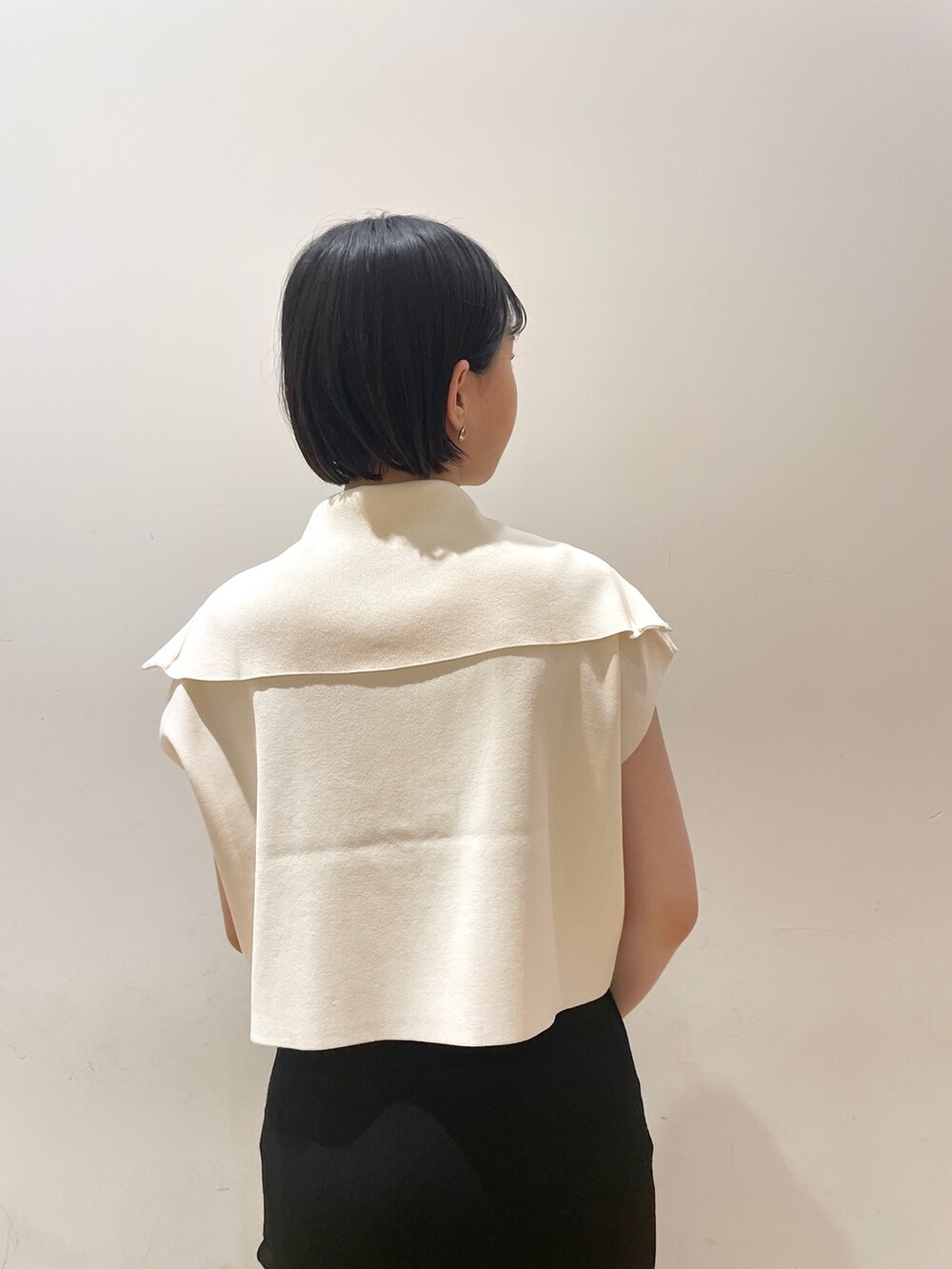 ブラック系のスカート、ホワイト系のニット/セーター、ブラウン系のハンドバッグを着用したレディースの春コーディネートの8枚目の写真