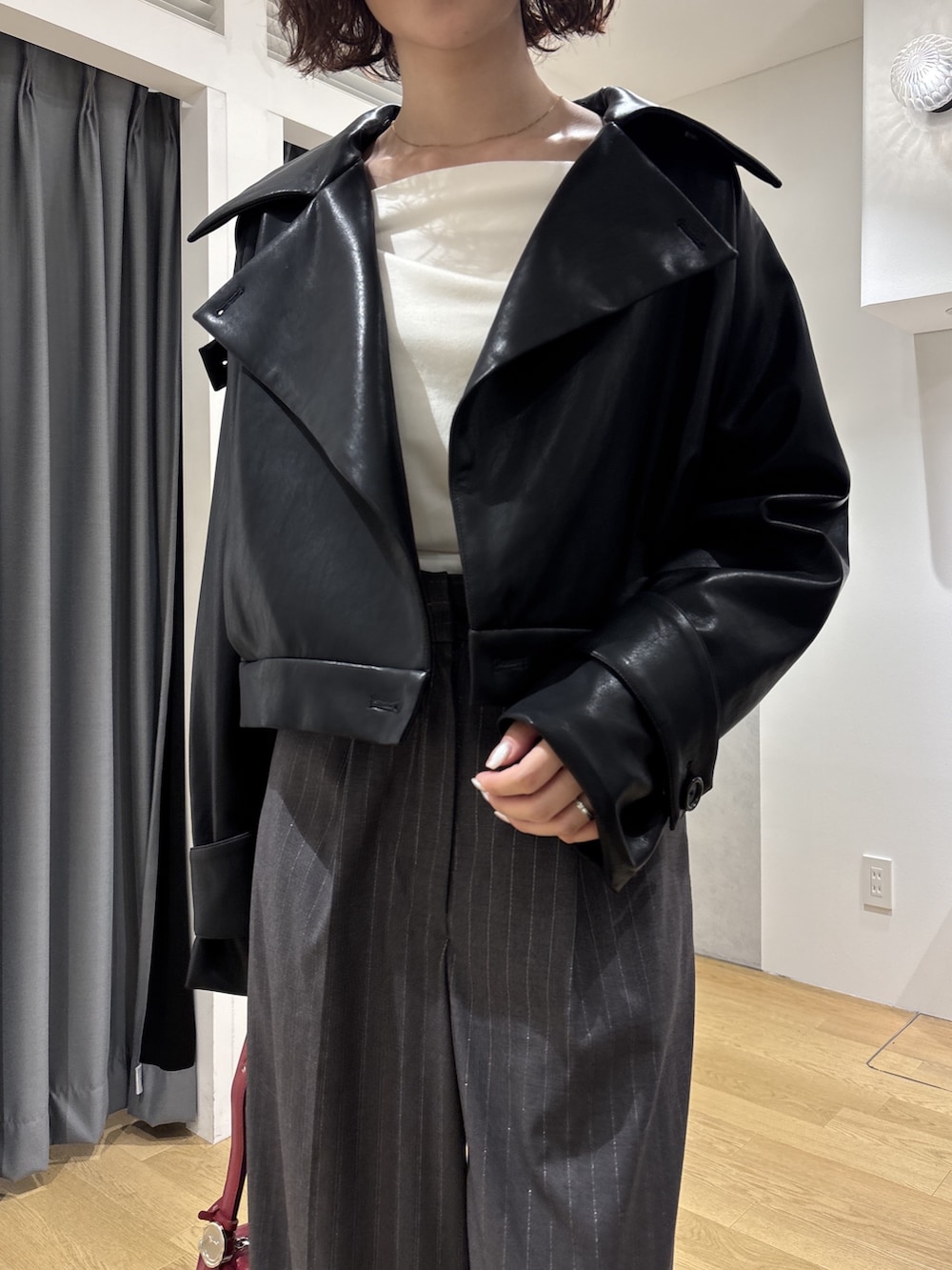 グレー系のその他パンツ、ホワイト系のニット/セーター、レッド系のハンドバッグを着用したレディースの秋コーディネートの5枚目の写真