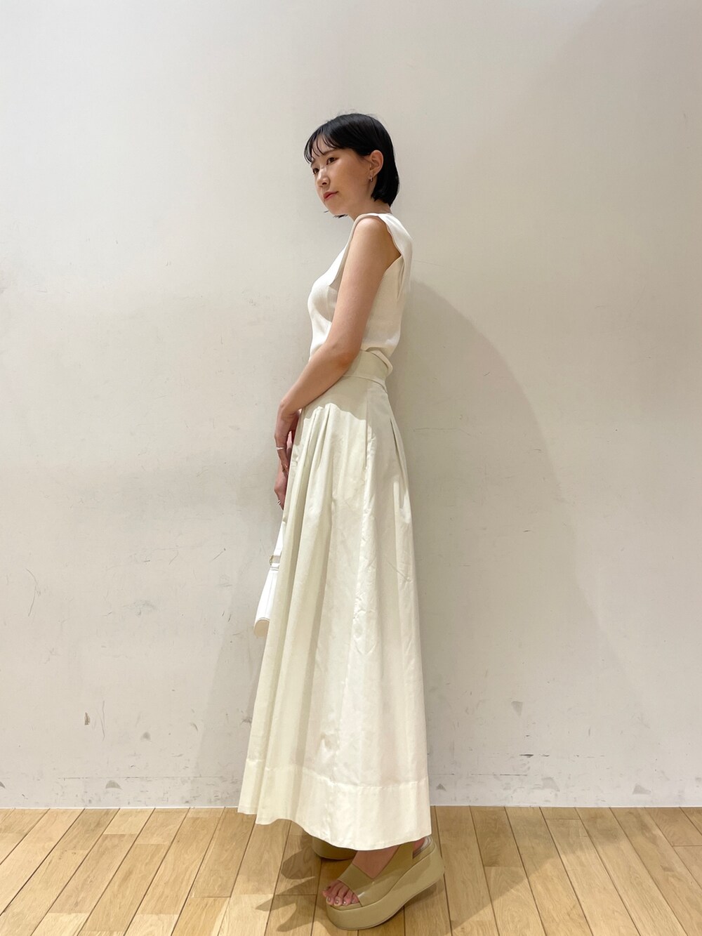 ホワイト系のニット/セーター、ホワイト系のスカート、ホワイト系のハンドバッグを着用したレディースの夏コーディネートの3枚目の写真