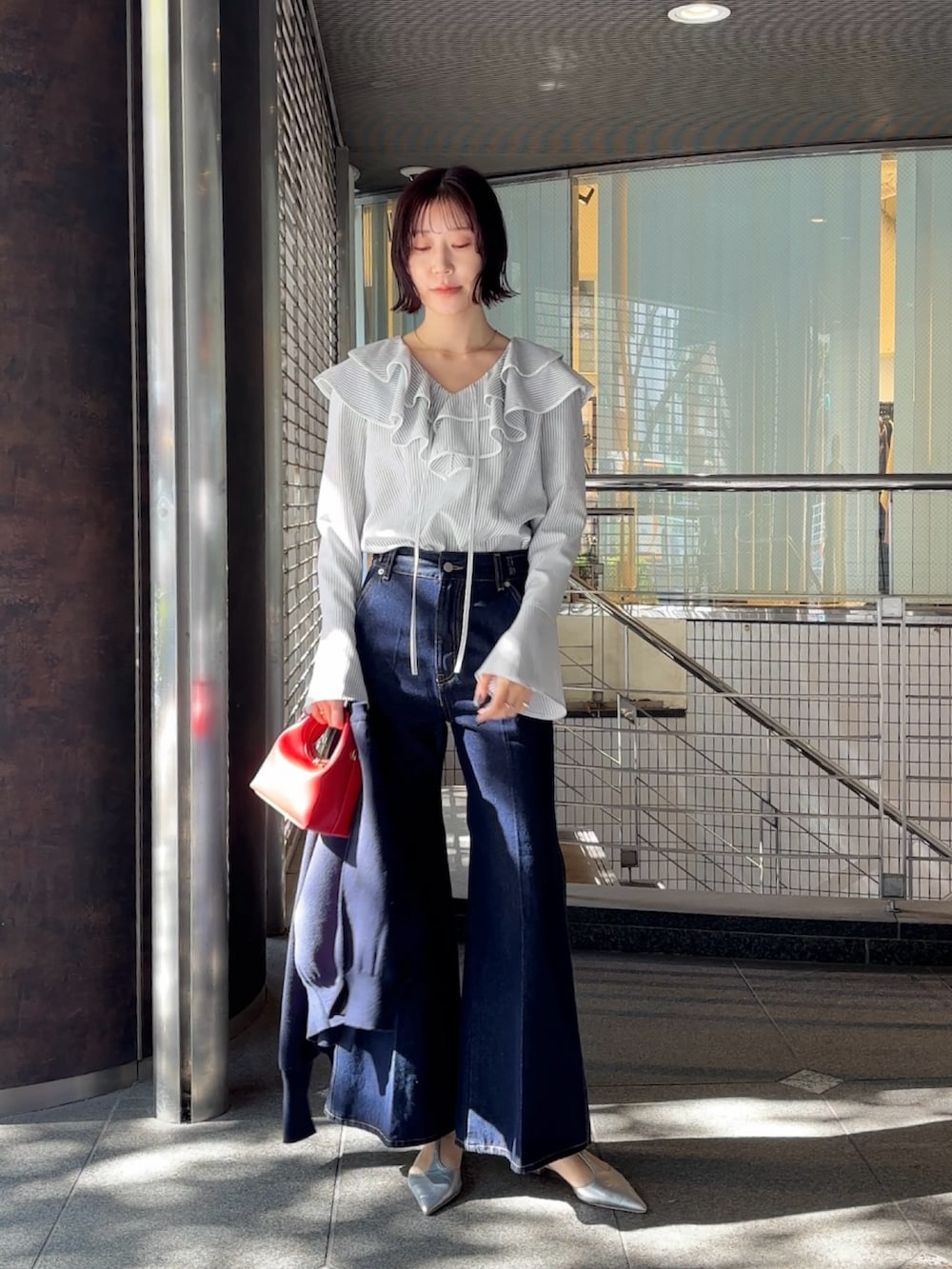 シルバー系のパンプス、ブルー系のカーディガン/ボレロ、ホワイト系のシャツ/ブラウスを着用したレディースの冬コーディネートの2枚目の写真