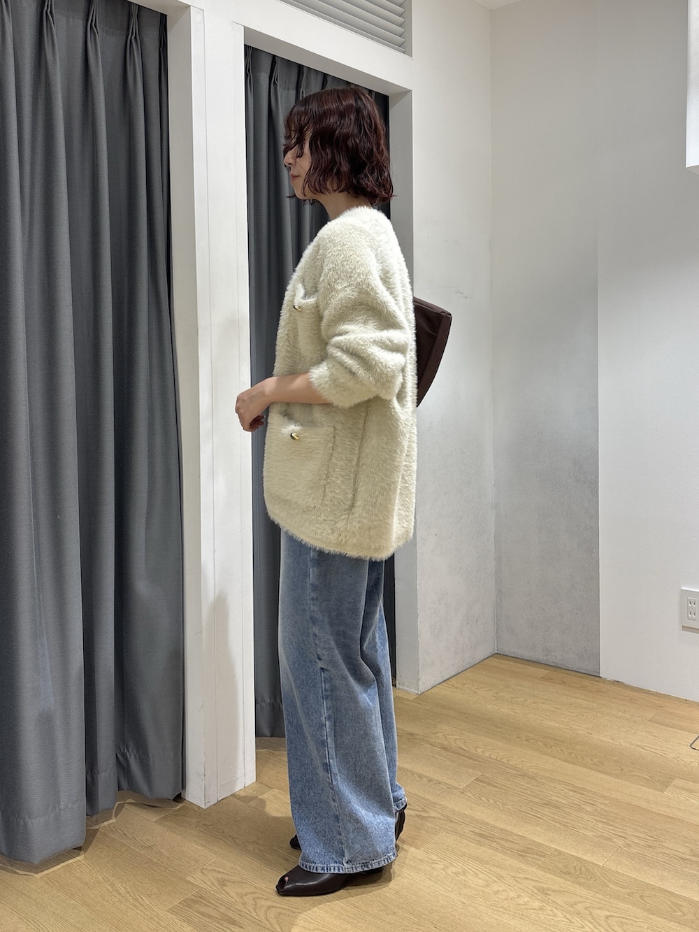ホワイト系のカーディガン/ボレロ、ブラック系のハンドバッグ、ホワイト系のTシャツ/カットソーを着用したレディースの秋コーディネートの3枚目の写真