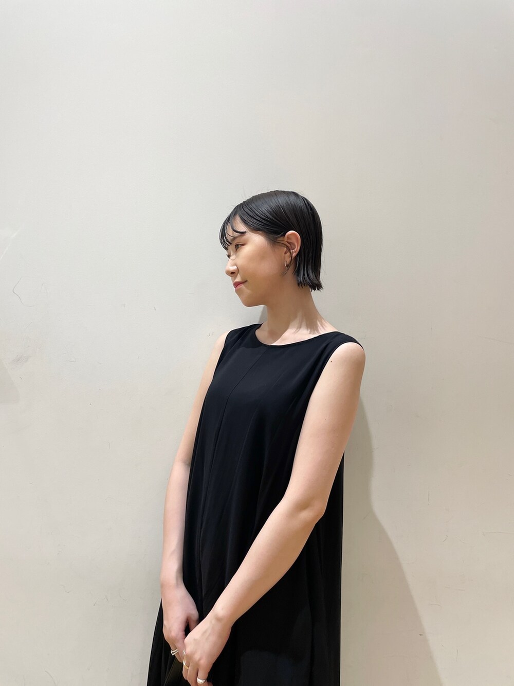 ブラック系のハンドバッグ、ベージュ系のテーラードジャケット、ブラック系のワンピースを着用したレディースの夏コーディネートの6枚目の写真