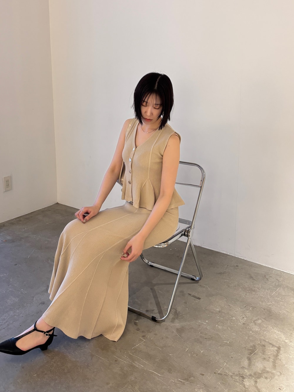 ベージュ系のニット/セーター、ベージュ系のスカート、ブラック系のパンプスを着用したレディースの春コーディネートの5枚目の写真