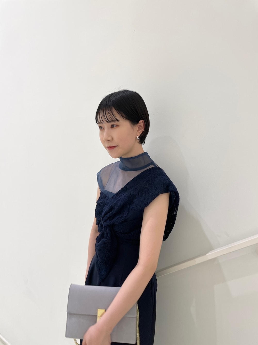 ブルー系のパンツドレス、グレー系のクラッチバッグ、グレー系のパンプスを着用したレディースの冬コーディネートの6枚目の写真