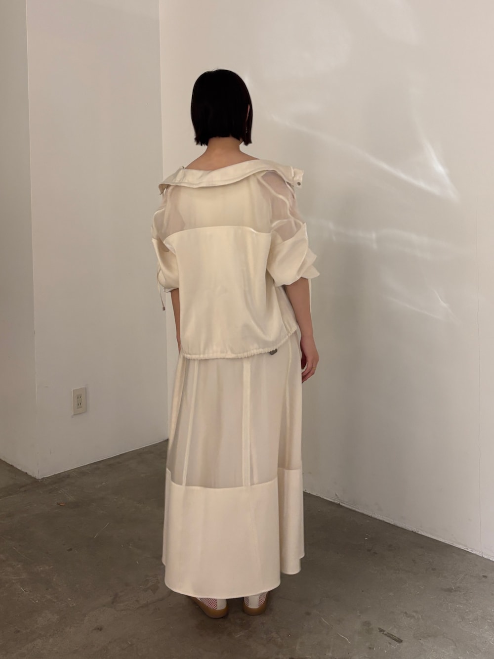 ホワイト系のスカート、ホワイト系のブルゾン、ホワイト系のタンクトップを着用したレディースの春コーディネートの6枚目の写真