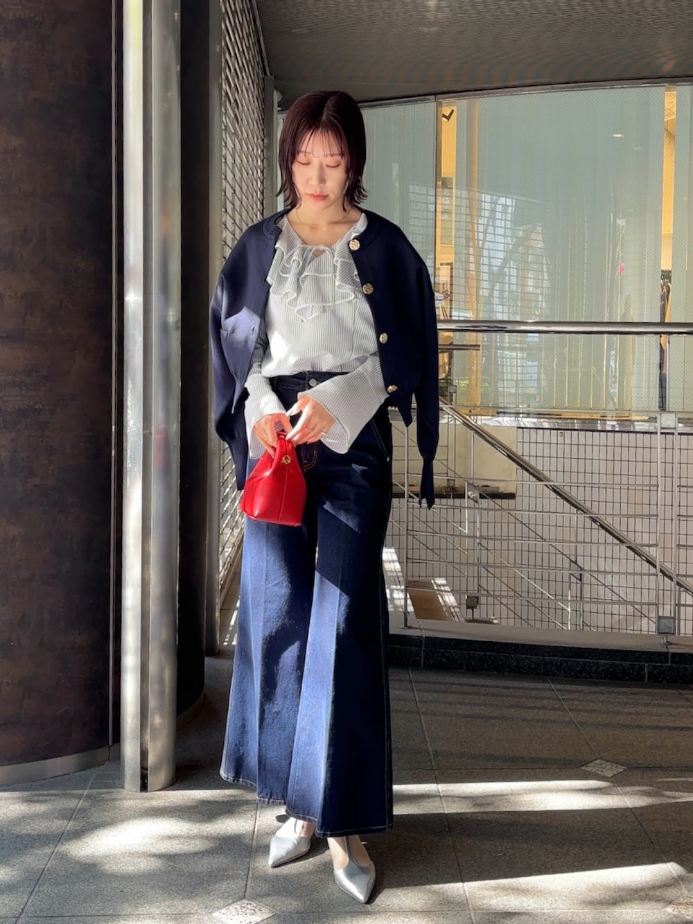 シルバー系のパンプス、ブルー系のカーディガン/ボレロ、ホワイト系のシャツ/ブラウスを着用したレディースの冬コーディネートの5枚目の写真