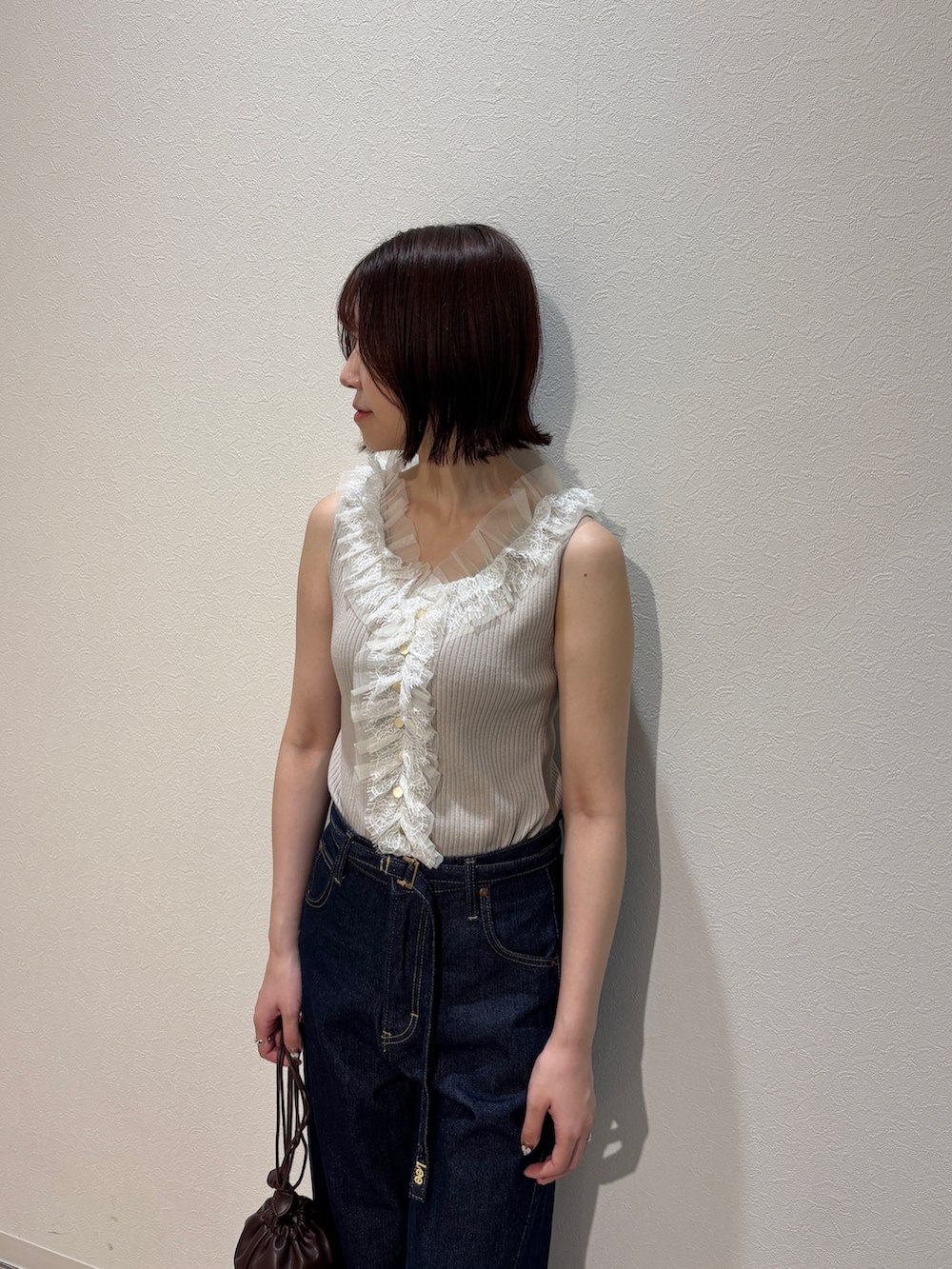 ベージュ系のニット/セーター、ブルー系のデニムパンツ、ブラウン系のサンダルを着用したレディースの夏コーディネートの5枚目の写真