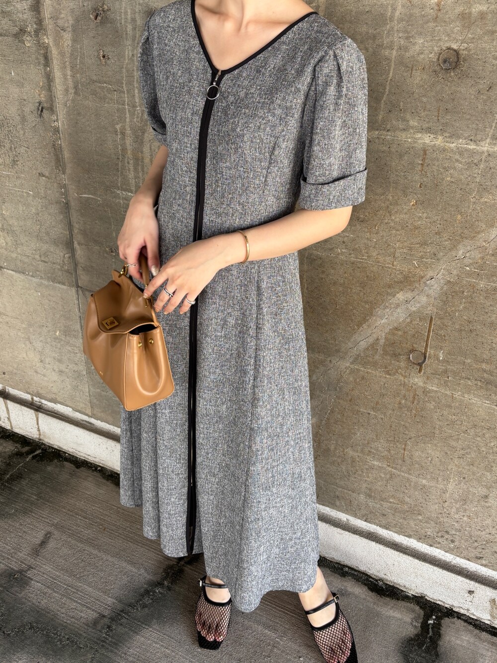 ブラック系のワンピース、イエロー系のハンドバッグ、ブラック系のサンダルを着用したレディースの夏コーディネートの7枚目の写真