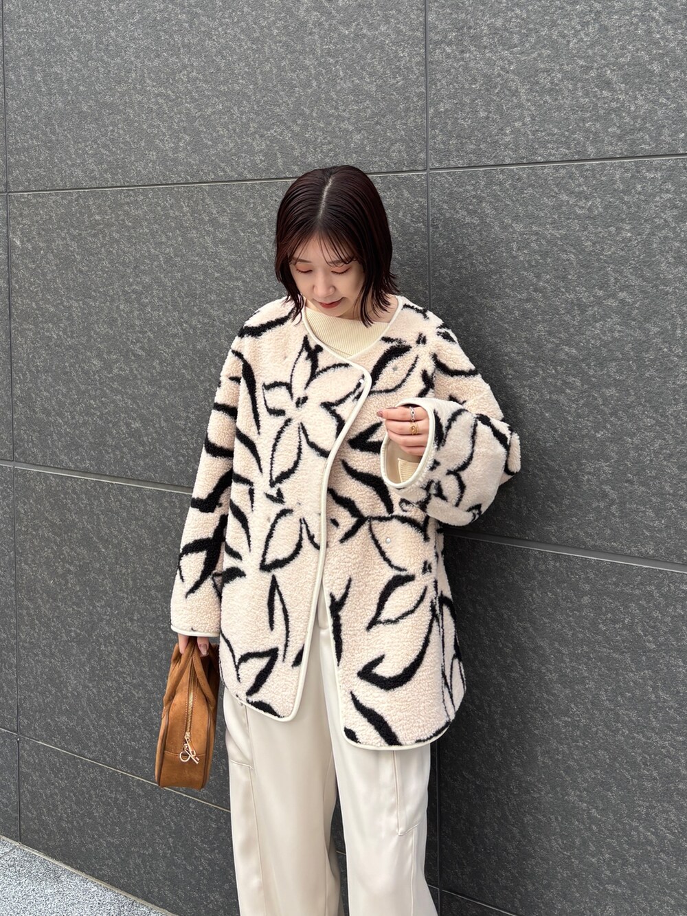 ホワイト系のブルゾン、ホワイト系のニット/セーター、ホワイト系のカーゴパンツを着用したレディースの冬コーディネートの4枚目の写真