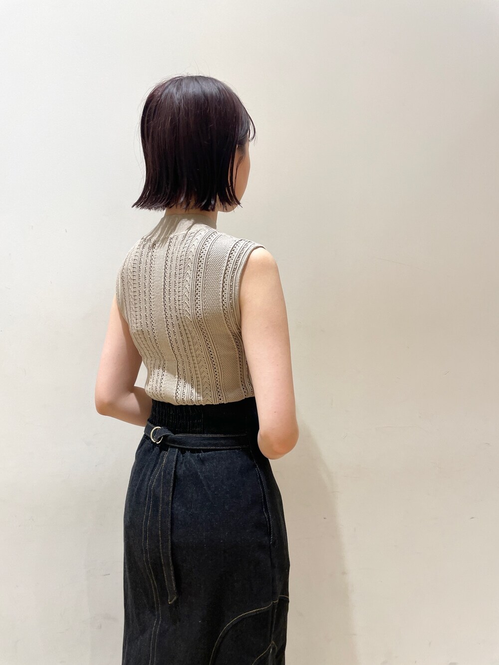 ベージュ系のニット/セーター、ブラック系のデニムスカート、ブルー系のサンダルを着用したレディースの夏コーディネートの7枚目の写真