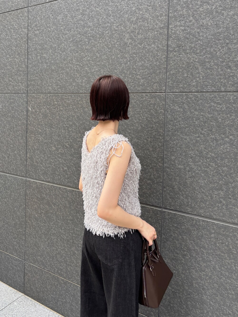 ブラウン系のパンプス、ブラック系のデニムパンツ、ブラウン系のボストンバッグを着用したレディースの夏コーディネートの6枚目の写真