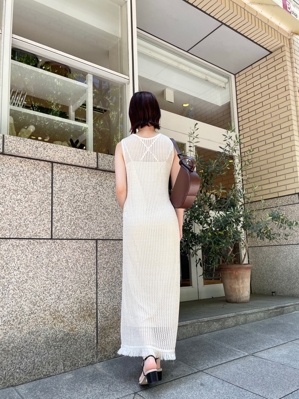 ブラック系のサンダル、ホワイト系のワンピース、ブラウン系のショルダーバッグを着用したレディースの夏コーディネートの4枚目の写真