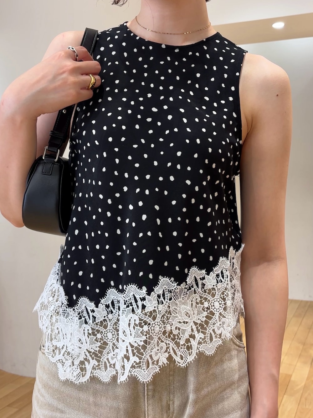 ベージュ系のデニムパンツ、ブラック系のシャツ/ブラウス、ブラック系のハンドバッグを着用したレディースの夏コーディネートの4枚目の写真