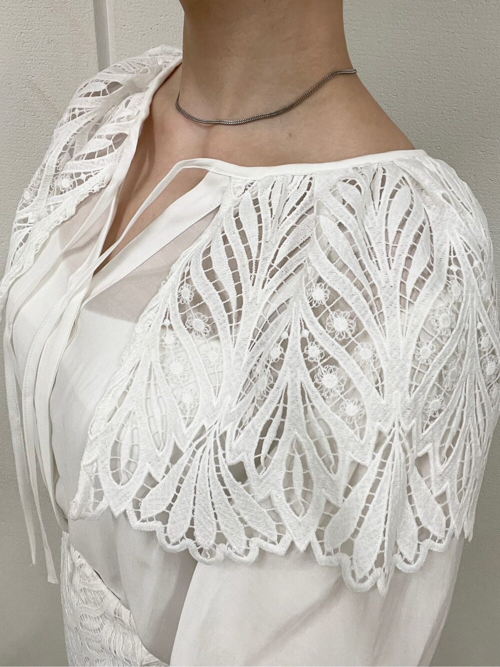 ホワイト系のシャツ/ブラウス、ベージュ系のスニーカー、ホワイト系のスカートを着用したレディースの春コーディネートの5枚目の写真