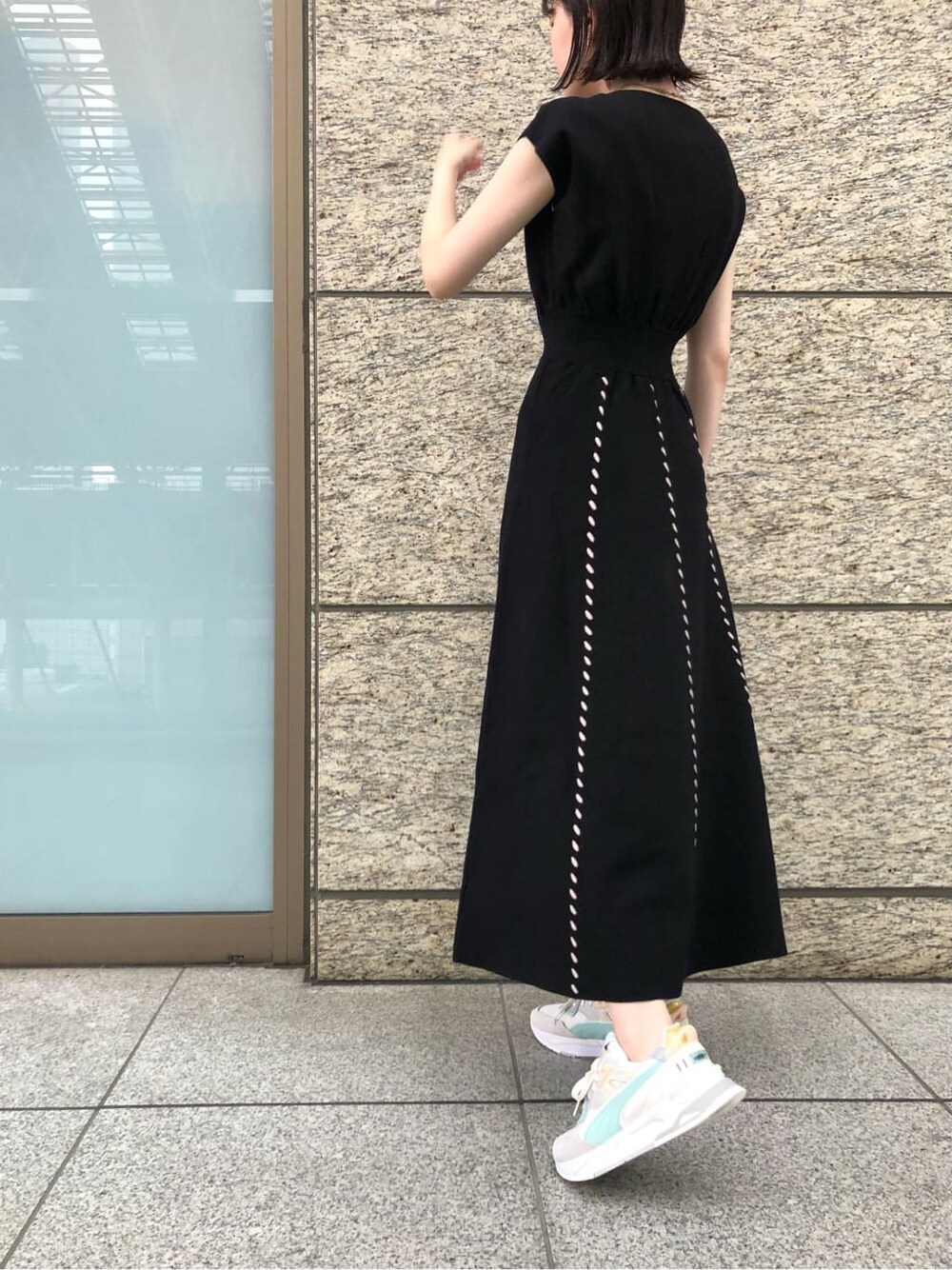 ブラック系のワンピース、ベージュ系のパンプス、ホワイト系のショルダーバッグを着用したレディースの夏コーディネートの7枚目の写真