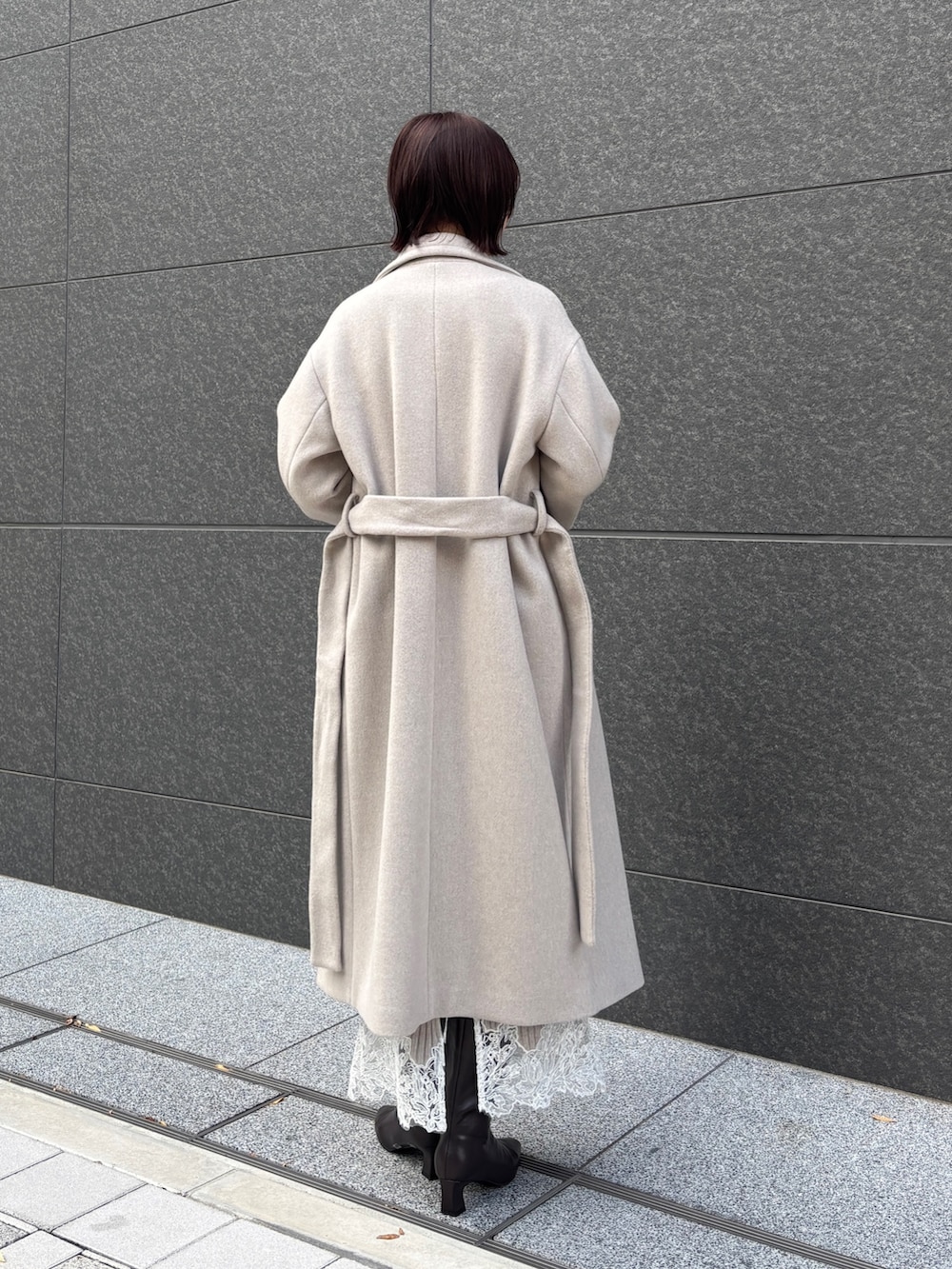 ベージュ系のワンピース、イエロー系のハンドバッグ、ブラウン系のブーツを着用したレディースの秋コーディネートの3枚目の写真