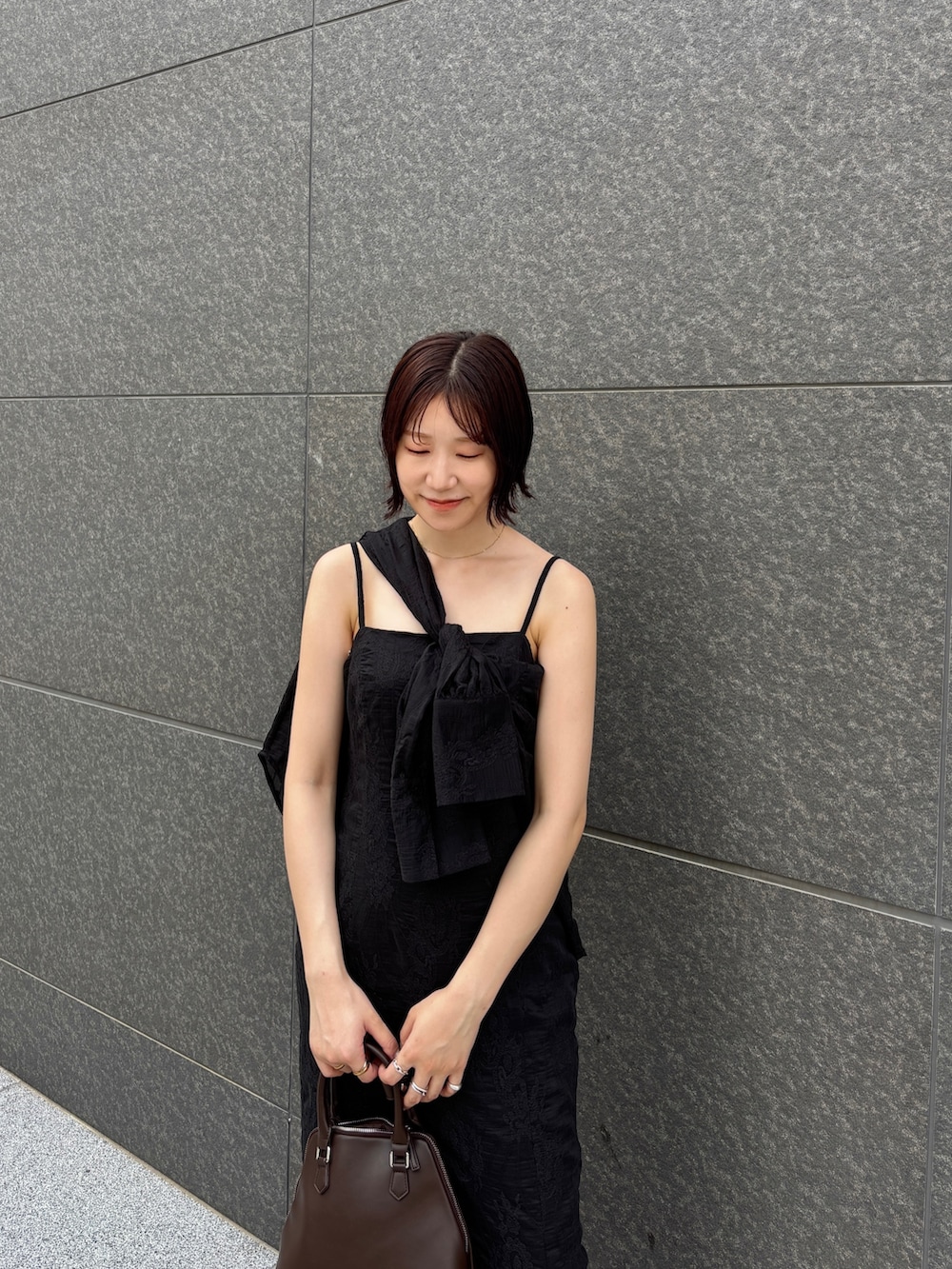 ブラック系のワンピース、ブラック系のシャツ/ブラウス、ブラウン系のボストンバッグを着用したレディースの夏コーディネートの3枚目の写真