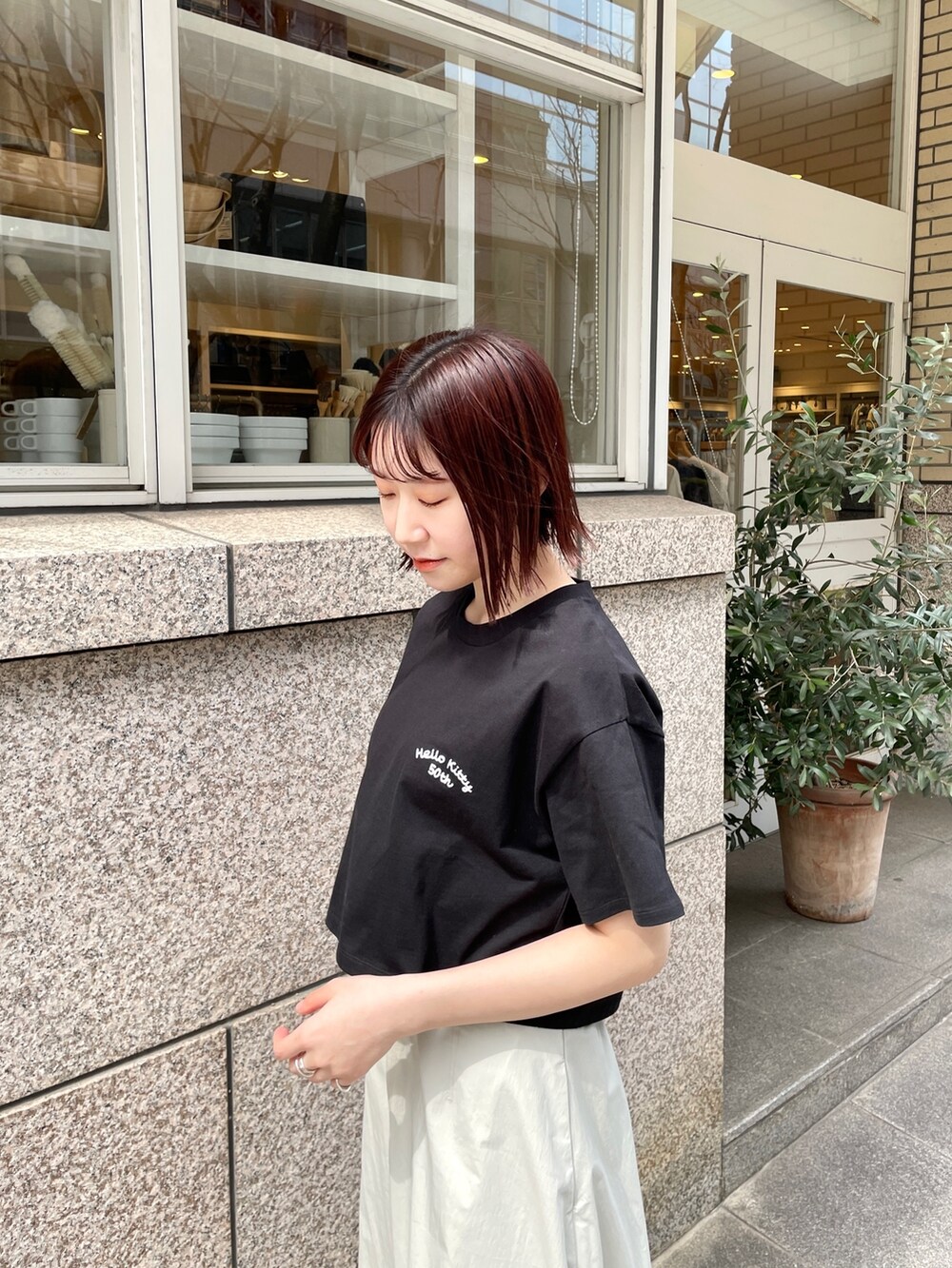 シルバー系のパンプス、ブラック系のTシャツ/カットソー、ホワイト系のスカートを着用したレディースの春コーディネートの6枚目の写真