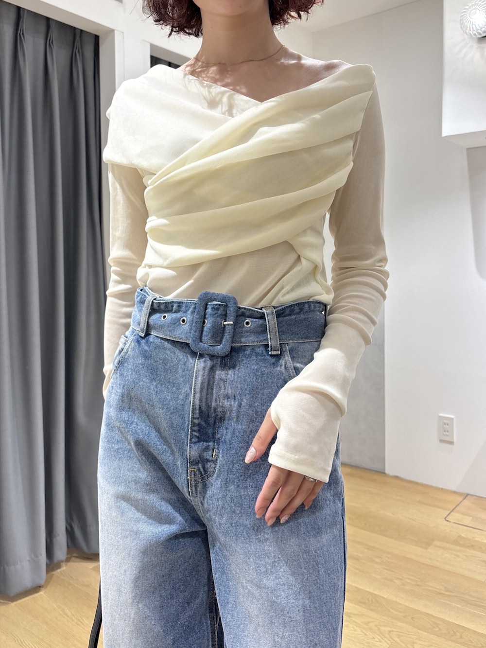 ホワイト系のTシャツ/カットソー、ブルー系のデニムパンツ、ブラック系のハンドバッグを着用したレディースの秋コーディネートの5枚目の写真