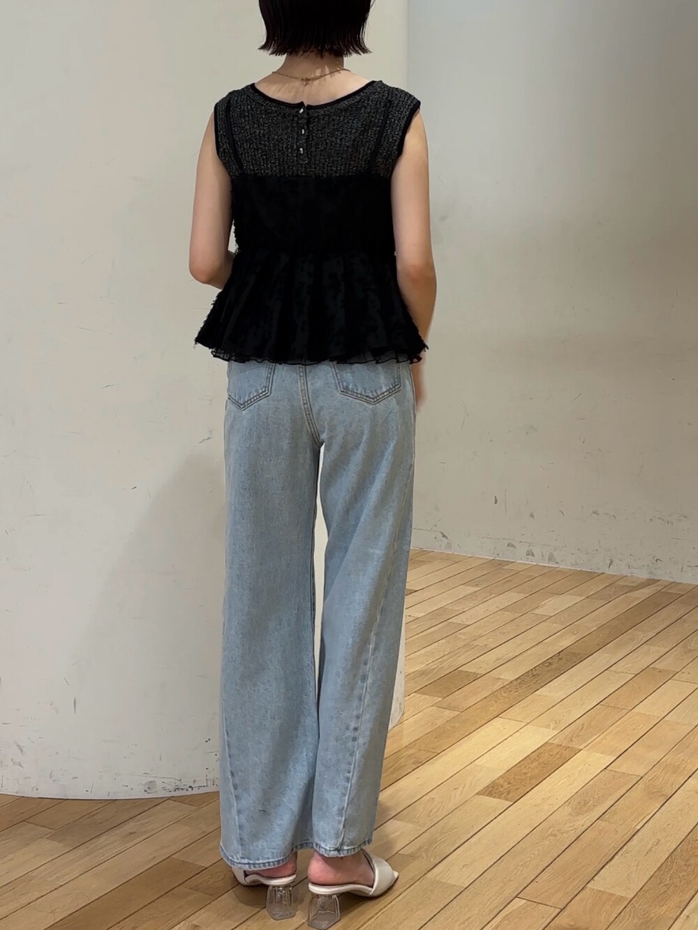 ブルー系のデニムパンツ、ブラック系のキャミソール、ブラック系のハンドバッグを着用したレディースの夏コーディネートの5枚目の写真