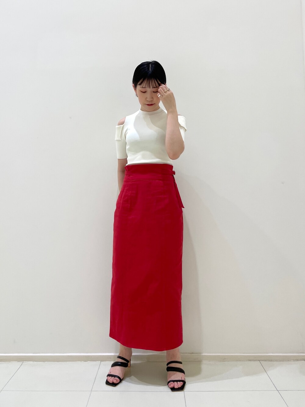 レッド系のスカート、ブラック系のサンダル、ベージュ系のテーラードジャケットを着用したレディースの春コーディネートの7枚目の写真