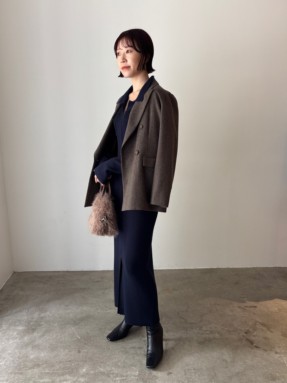 ブルー系のワンピース、ブラウン系のテーラードジャケット、ブラウン系のボストンバッグを着用したレディースの秋コーディネートの3枚目の写真