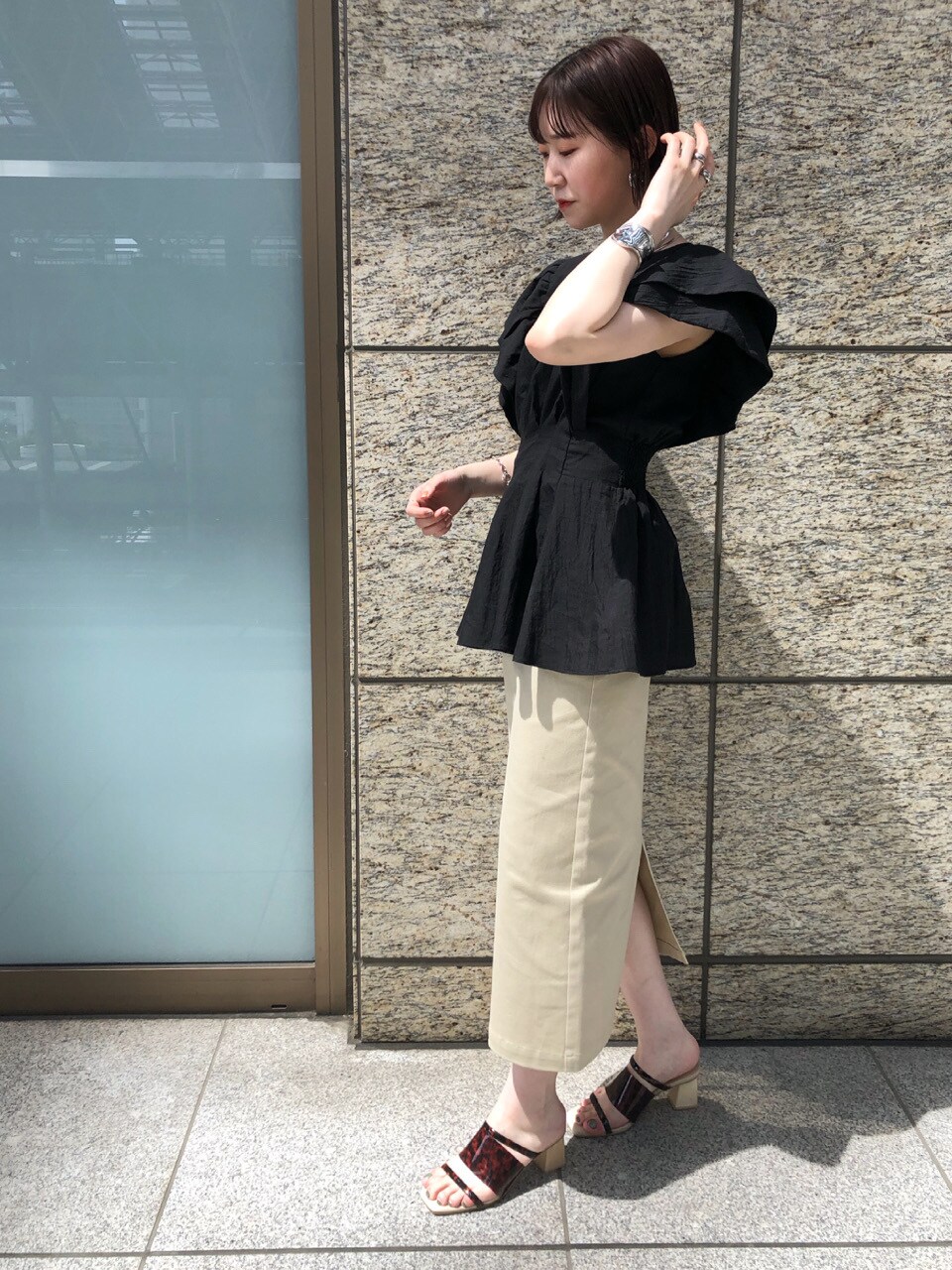 ブラック系のシャツ/ブラウス、ベージュ系のスカート、その他のその他シューズを着用したレディースの春コーディネートの2枚目の写真