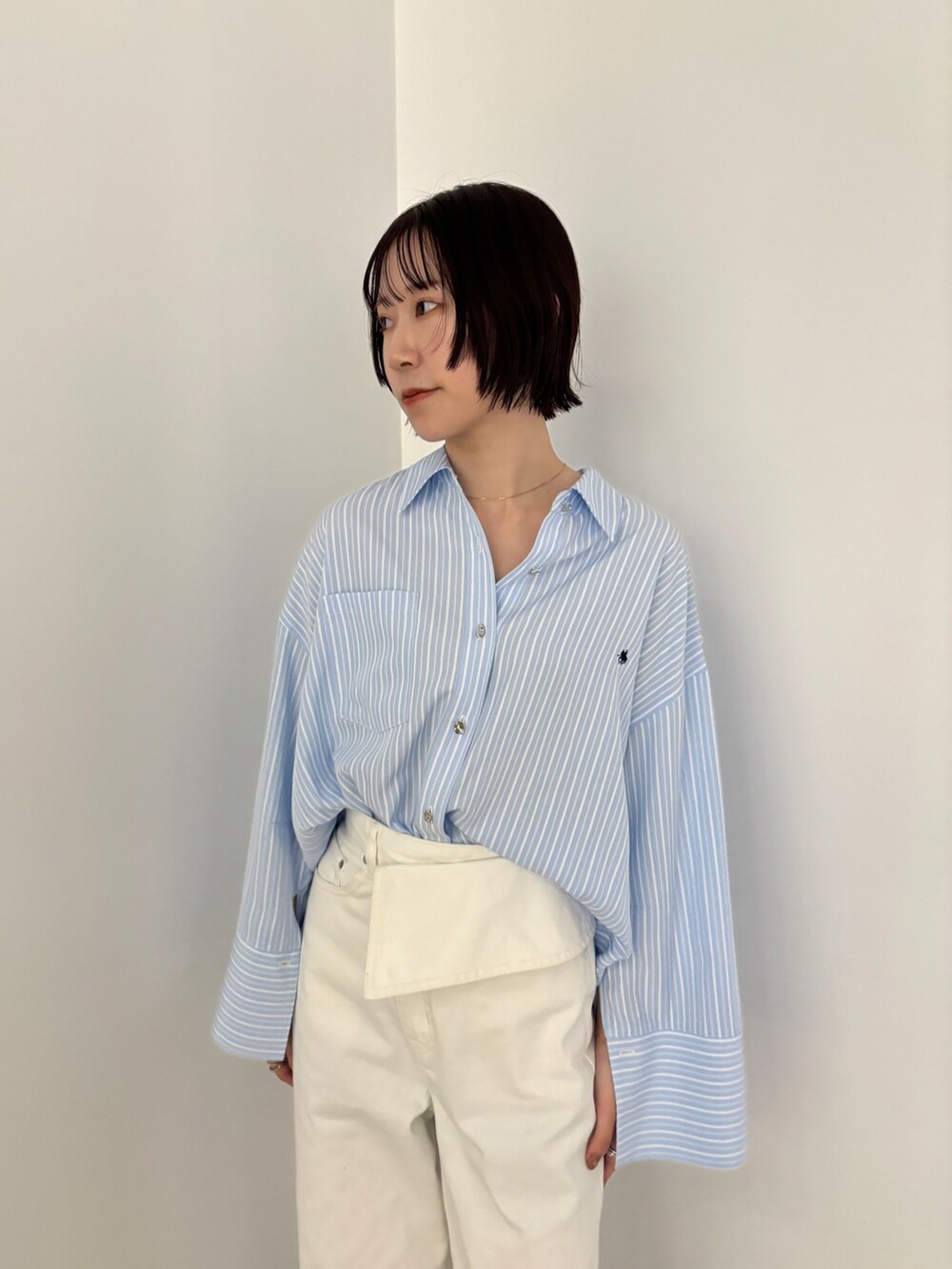 ブルー系のシャツ/ブラウス、ホワイト系のデニムパンツ、ホワイト系のサンダルを着用したレディースの冬コーディネートの5枚目の写真