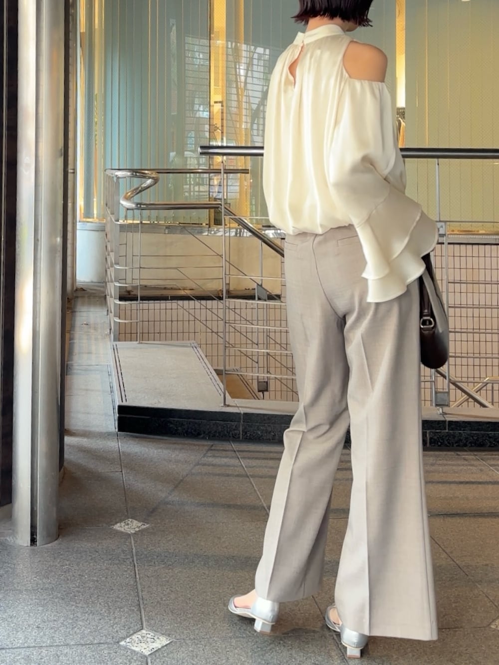 シルバー系のパンプス、ブラウン系のハンドバッグ、グレー系のその他パンツを着用したレディースの冬コーディネートの4枚目の写真