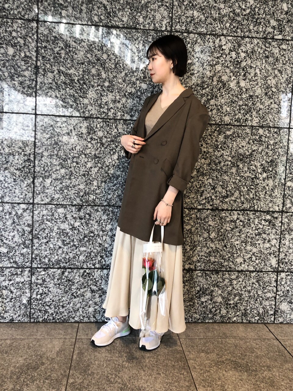 ベージュ系のニット/セーター、ホワイト系のスニーカー、ホワイト系のスカートを着用したレディースの春コーディネートの3枚目の写真